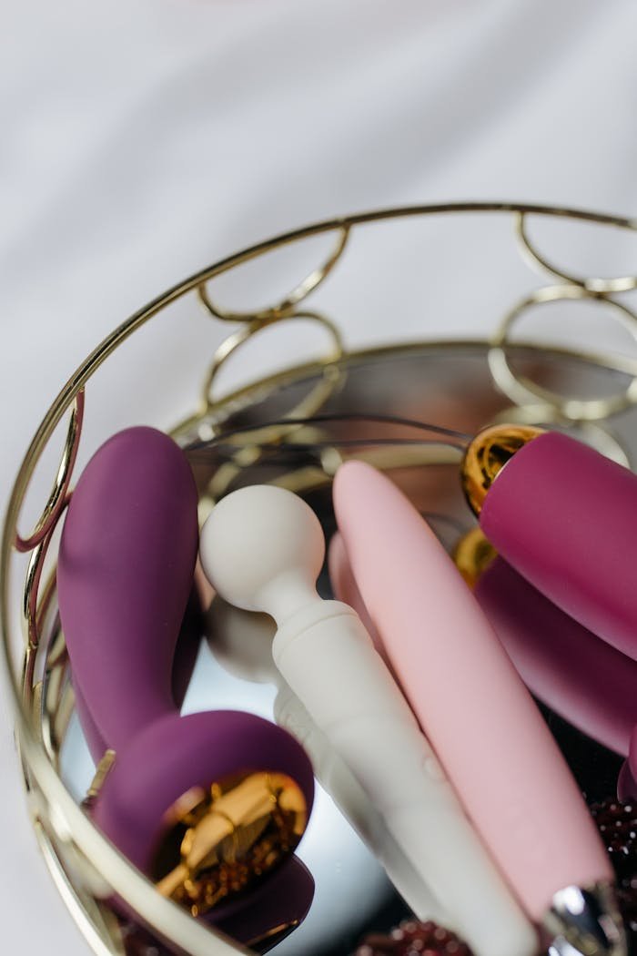 Close-up of various colorful adult toys arranged in an elegant metal basket, ideal for lifestyle shoots.